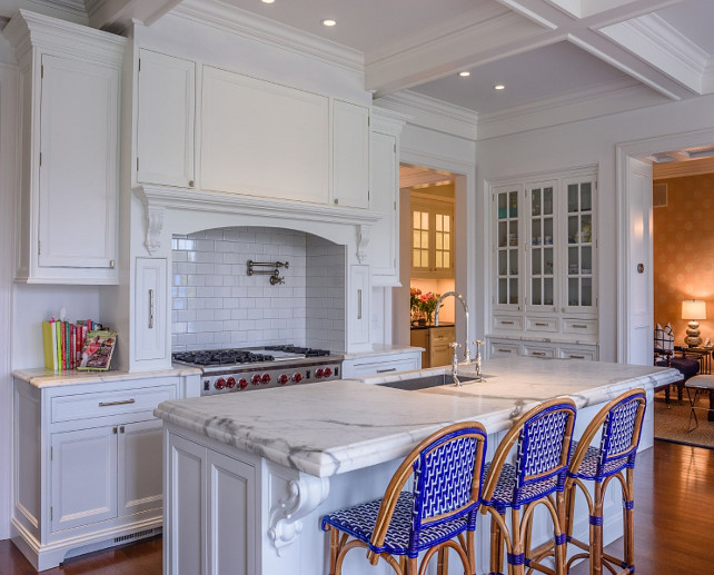 Blue kitchen counter stools. White kitchen with custom hood with white subway tile backsplash, swing warm pot filler and spice cabinets on hood. The kitchen island feautures French blue counter stools. #Kitchen #BlueCountertsool #WhiteKitchen Via Sotheby's Homes.