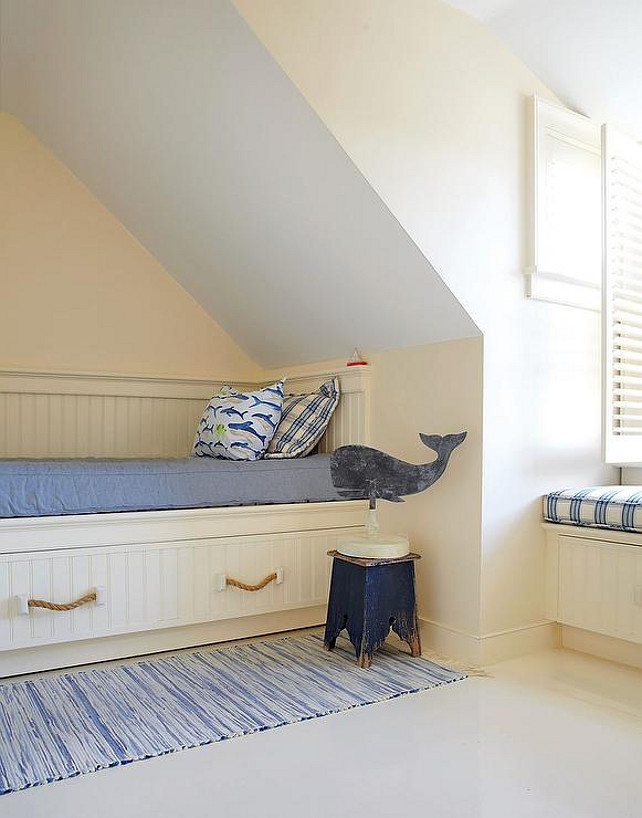 Dormer Bedroom Ideas. Dormer Bedroom Layout. Attic cottage kids' bedroom features a built-in bed clad in beadboard trim and fitted with rope pulls topped with a blue denim cushion, shark pillow and a blue gingham pillow next to a weathered blue stool atop a blue runner alongside a built-in window seat.. #Dormer #Bedroom #Attic #layout Botticelli and Pohl Architects.