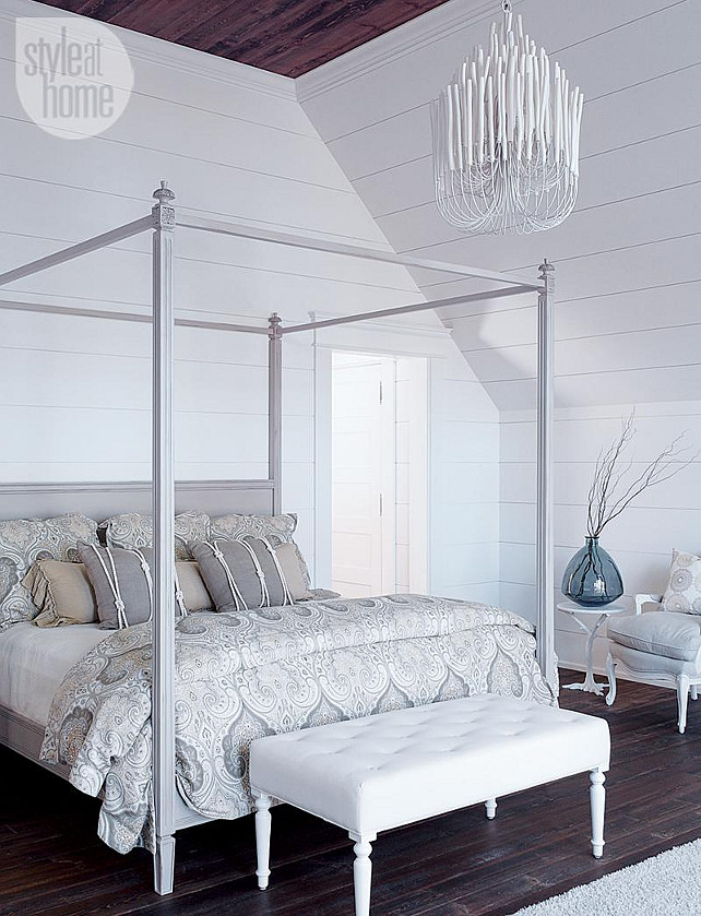 Coastal Bedroom. Coastal Bedroom Lighting Ideas. In the master bedroom, a soft grey, white and taupe palette keeps the four-poster bed from looking too dramatic, especially when paired with an equally riveting chandelier made of tapered wood pieces. Via Style at Home. #Bedroom #Lighting #Chandelier