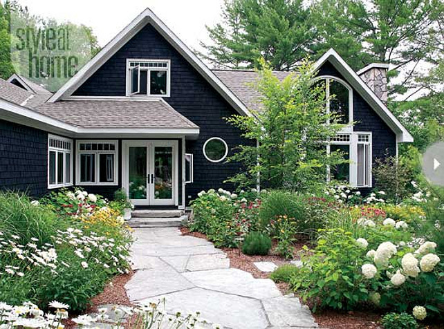 Home Exterior Ideas. Cottage Exterior. A range of sun-loving plants makes up the cottage’s landscaping. The white, yellow and red blooms are in sync with the interior’s colour palette. #Cottage #Home #Exterior David Spolnik.