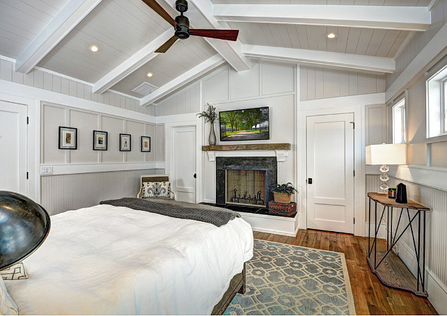 Bedroom Fireplace. Beach house bedroom. Beadboard Bedroom. Board and batten. Corbels. Grey walls. High windows. Master bedroom. Reclaimed wood mantel. Shiplap. Tongue and groove. White beam. White doors. White trim. Wood walls