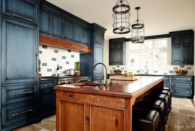 Kitchen. Rustic Kitchen with Navy Blue Cabinets. Rustic kitchen with navy blue cabinets. The hand-crafted island, topped with an 11-foot cut of distressed cherrywood, seats five and functions as the chef's table for the husband, an avid cook. The perimeter cabinetry is cherrywood painted Mozart Blue by Benjamin Moore with black glaze. #BenjaminMooreMozartBlue #Kitchen #Cabinet #PaintColor #BlueKitchen #NavyKitchen Heidi Piron Design.