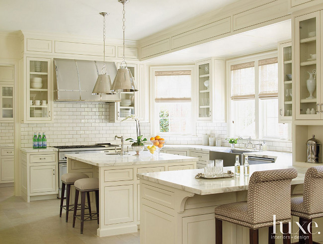 Kitchen. Classic Kitchen. This classic kitchen kitchen includes custom barstools (foreground) covered in Nobilis fabric, which pull up to a honed Calacatta marble countertop. Custom cabinetry continues the room’s sophisticated white-on-white palette. #Kitchen #Classic Courtney Hill Fertitta.