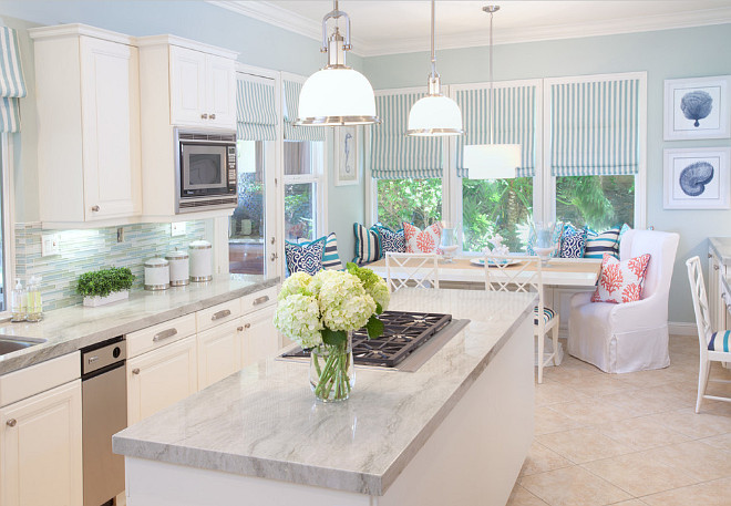Coastal Kitchen. White and blue cottage kitchen features white cabinets paired with quartzite countertops and blue glass tiled backsplash. #Coastal #Kitchen #BlueglassBacksplash #Quartzite AGK Design Studio.
