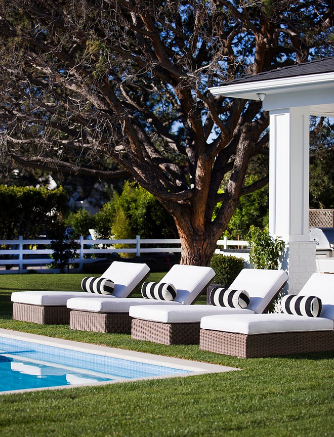 Pool Lounges with white cushion and black and white lumbar pillows.