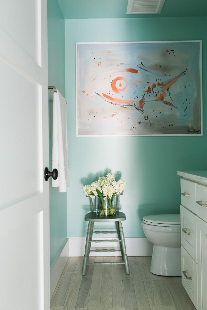 Powder Room. Attached to the mudroom, this powder room is the main bathroom for guests. The walls are covered in the same beach-y shade of gray-green used in the mudroom.