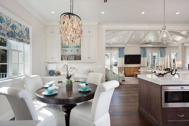 Breakfast nook. Breakfast nook with custom upholstered chairs, our favorite Currey & Co oyster chandelier and a custom flat romans shade that sit in front of extra cabinetry and a built in desk. #breakfastnook