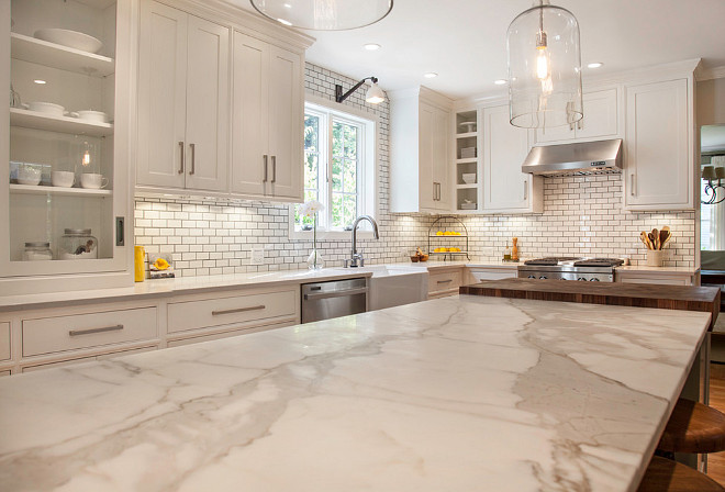 Off-white kitchen with honed Calacatta gold marble countertop. #Offwhitekitchen #OffwhitekitchenCountertop #OffwhitekitchenhonedCalacattagoldmarblecountertop #honedCalacattagoldmarblecountertop New England Design Works