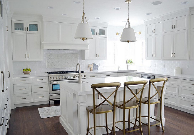 All white kitchen ideas. This kitchen features gorgeous quartz countertops, a white beveled subway tile, with a pretty marble herringbone accent, beautiful brass hardware and lighting. #Whitekitchen #allwhitekitchen Sita Montgomery Interiors