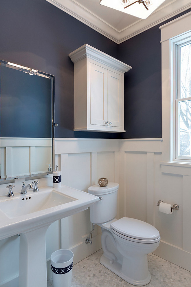 Board and Batten Bathroom. What a great bathroom design! I love the combination of board and batten wainscoting with navy walls painted in Newburyport Blue by Benjamin Moore. The board and batten wainscoting was enameled in BM White Dove. The wainscoting was installed using multiple trim boards at approximately 54" height. The floor tile is a marble hexagon. Board and batten wainscoting. Board and Batten Bathroom Wall. Board and Batten Bathroom Dimensions. Small Bathroom with Board and Batten. #BoardandBatten #Bathroom Designed by Grace Hill Design