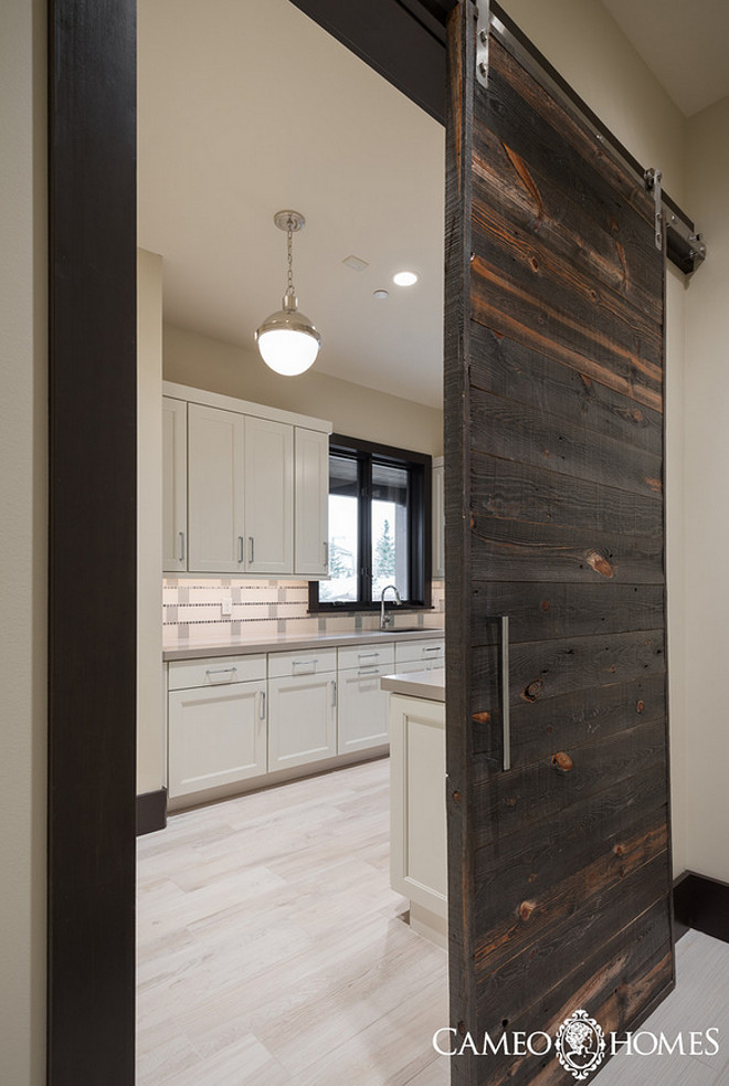 Laundry Room with a sliding barn door made of reclaimed wood. Laundry Room with a sliding barn door made of reclaimed wood ideas. #LaundryRoom #slidingbarndoor #reclaimedwooddoor Cameo Homes Inc.