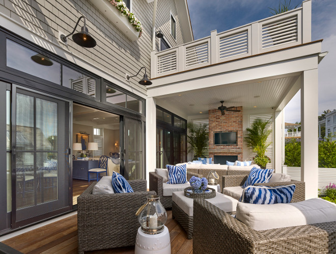 Deck. Sliding patio doors open to an Ipe deck with wicker furniture, outdoor fireplace with outdoor tv and a second floor roof porch with louvered railings. #Deck #Outdoorliving #Ipedeck #Deckideas #Outdoorfireplace #Outdoors Asher Associates Architects. Megan Gorelick Interiors