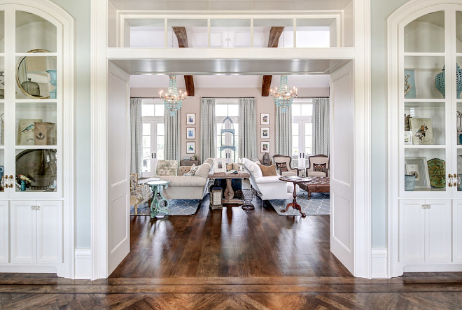 Arched built-in cabinets frame a wide doorway with transoms leading to the formal living room. Artisan Signature Homes.