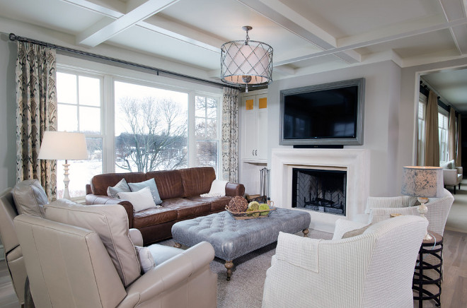 Neutral living room painted in Revere Pewter by Benjamin Moore, Limestone fireplace, whitewashed hardwood floors and lattice drum pendant light. Mike Schaap Builders