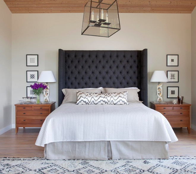 Oversize gray wool tufted headboard adds mass and drama to the master suite. Lamps made from reclaimed antique carved relics, antique Morroccan rug adds texture and warmth. Savant Design Group