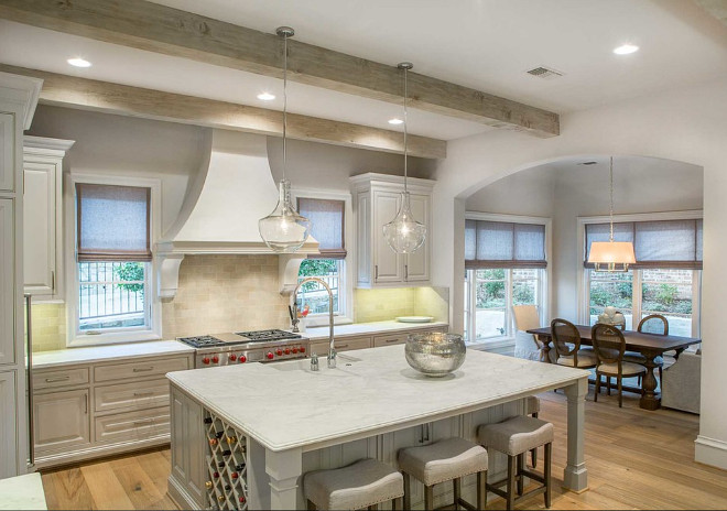 French kitchen with graywashed cabinets and island. French kitchen features also whitewashed ceiling beams and seeded glass pendants above island. Pendants above island is Jamie Young Seeded Glass Nimbus 3 Light Chandelier. 