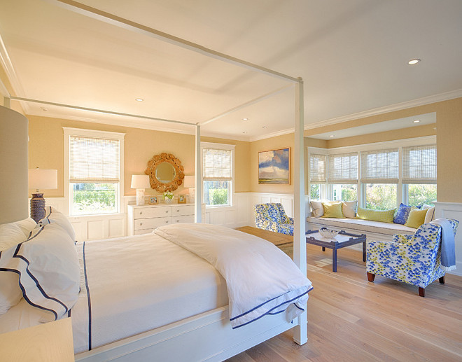Bedroom. Bedroom features light tan walls, white four poster canopy bed and a charming window seat. #Bedroom.