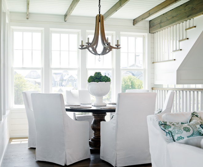 Dining Room Decor Ideas. Coastal inspired dining room. This dining room has everything I love; plenty of natural light, a round table and white slipcovered dining chairs. Chairs are from Lee Industries. Chandelier is Manning 6 Light Chandelier from Arteriors #CoastalDiningRoom #DiningRoom #Coastalinspired #coastalhomes #diningroomdecor #Chandelier #ArteriorsChandelier T.S. Adams Studio, Architects 
