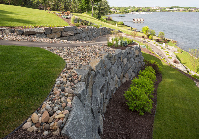 Tiered garden ideas. Tiered garden with retainer walls made of Bluestone. This blue-stone lined trail down to the lake makes for a great walk to the water. The walk is surrounded by beautiful shrubs that offer a variety of seasonal color. #Tieredgarden #retainerwalls #bluestone #retainergardenwall Southview Design
