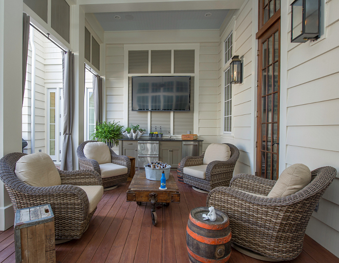 Outdoor Porch with TV. This outdoor porch features a TV and a built-in outdoor kitchen. Countertop – Black Absolute granite honed. Ratana Swivel Chairs. Exterior Lights –The Copper Lighting Co. Custom – Outdoor Draperies. #OurtdoorTV #Porch #TVPorch #outdoorkitchen Interiors by Courtney Dickey and T.S. Adams Studio.