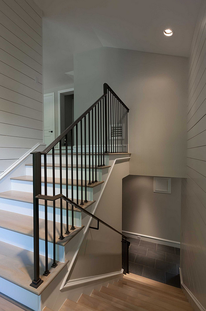 Staircase shiplap walls, white oak hardwood floors with whitewash finish and wrought iron stair balusters and handrail. #staircase #shiplap #wroughtironstairs #balusters #handrail #whiteoakfloor Connie Anderson Photography. Elizabeth Garrett Interiors