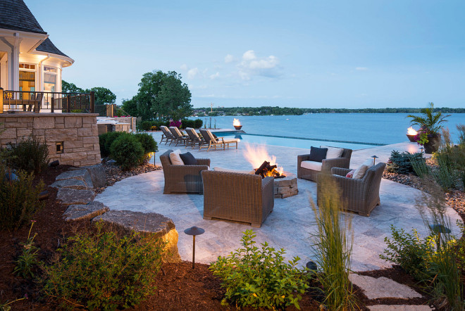 Backyard. There is nothing like a firepit with a view. This lovely firepit overlooks an infinity swimming pool and the firebowls on either side of the pool frame the lake nicely making this area a great place to take in the evening with friends and family. #backyard Southview Design. Eskuche Design.