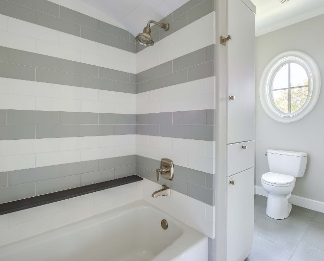 Bathroom striped tiles. Bathroom features white and gray subway tiles alongside a built-in shelf. #bathroom #stripedtiles #subwaytiles Elizabeth Garrett Interiors.
