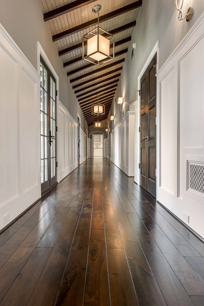 Hall Lighting. Hall. Lighting. Long hall features a sloped ceiling, dark stained wood beams and caged Lanterns with Paper Shades. Hall also features top part of walls painted gray and lower walls clad in board and batten. #hall #halllighting #lighting Elizabeth Garrett Interiors.