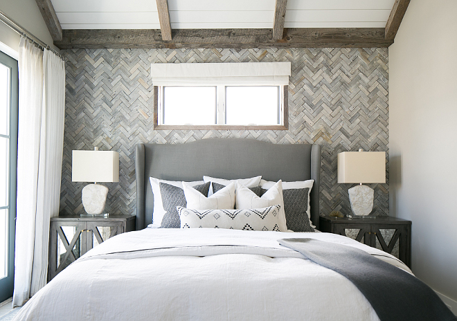 Master bedroom wall features white washed reclaimed wood in a herringbone pattern. Patterson Custom Homes