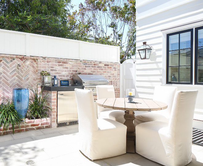 This courtyard features concrete paver flooring, exposed brick walls and white fencing on top to add extra privacy. Patterson Custom Homes. Interiors by Trish Steele, Churchill Design.
