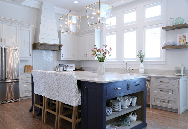 White kitchen with reclaimed cabinets and blue island. Reclaimed white kitchen cabinets with navy blue island and Bianco Macaubus Quartzite countertop. #whitekitchen #reclaimedwhitekitchen #reclaimedwhitecabinet #blueisland #bluekitchenisland #BiancoMacaubusQuartzite Old Seagrove Homes.