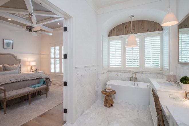 Bathroom. Adding texture to bathrooms. In the bathroom, the arch above the window features cypress planks with a weathered oak stain. The master bedroom ceiling is wallpapered in Phillip Jeffries grasscloth. #bathroom #texture Interiors by Courtney Dickey of TS Adams Studio.