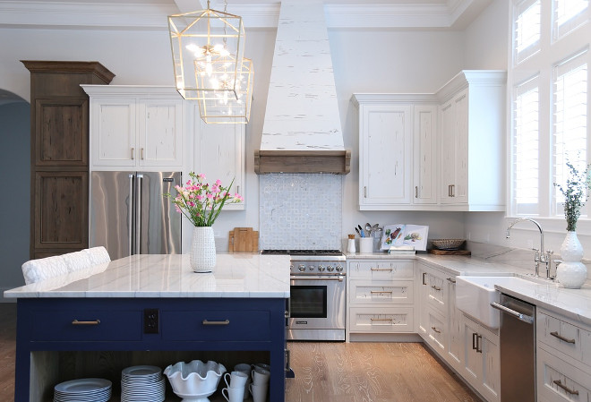 Blue and white kitchen. Kitchen with white cabinets and blue island. Countertop is Bianco Macaubus Quartzite. #blueandwhitekitchen #whiteandbluekitchen #blueandwhite #kitchen #interiors Old Seagrove Homes.