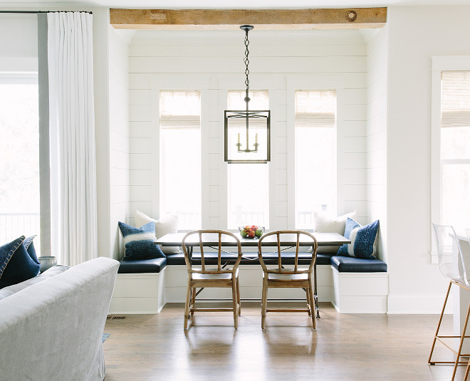 Breakfast nook banquette with reclaimed wood ceiling beams and white shiplap walls. Breakfast nook banquette with reclaimed wood ceiling beams and white shiplap walls. Kate Marker Interiors.