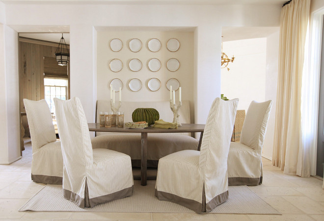 Dining room wall plates Neutral dining room painted in a creamy white paint color and white plates hung on the wall niche. Urban Grace Interiors