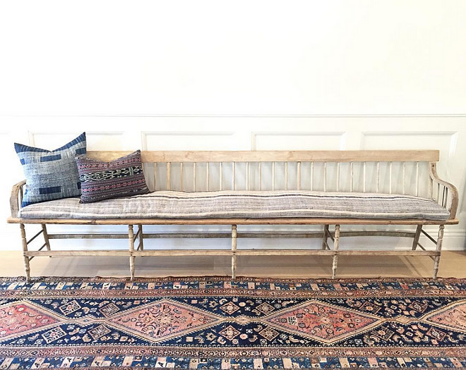 Foyer with extra long vintage bench with vintage pillows and vintage rug. #Foyer #vintagefurniture #vintagerug #vintagedecor #vintageinteriors #vintagepillows #vintagebench #wainscoting Amber Interiors