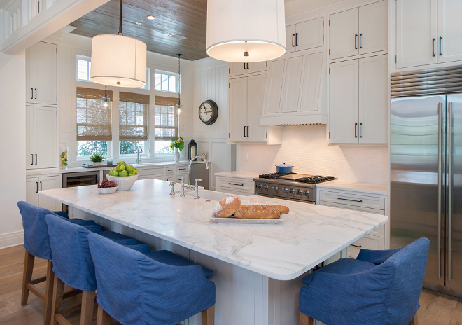 Kitchen. I have to say that I fell in love with this kitchen! Kitchen cabinets are painted in Benjamin Moore White Dove with Ashley Norton Hardware. The countertop is Calcutta Gold Extra. Backsplash is Matchstick Mosaic in white. The kitchen stools are from Lee Industries slipcovered in Perennials fabric - great for ease of washing and keeping clean. Wood floors are Character Grade Oak in Heritage finish. Pendants are Barbara Barry French Cuff Single Pendant in Bronze. #kitchen #coastalkitchen #benjaminmoorewhitedove #benjaminmoorewhitedovekitchen #benjaminmoorewhitedovecabinet #kitchenlighting #pendants #countertop #backsplash Courtney Dickey of TS Adams Studio. 