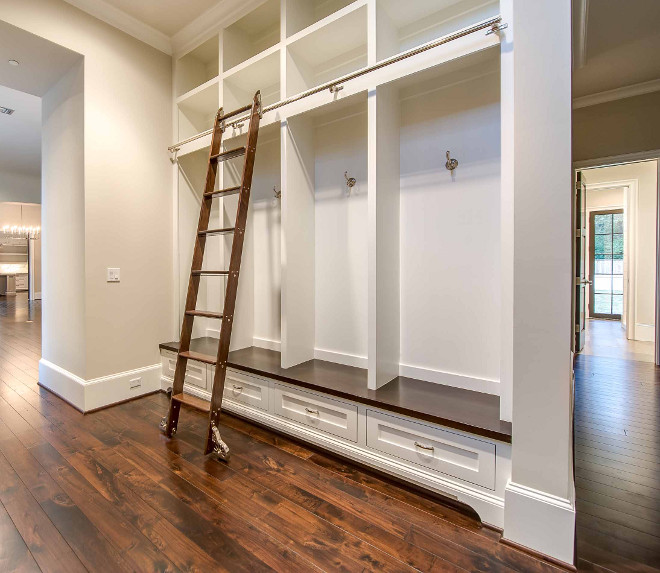Mudroom ladder. Mudroom features a full wall fitted with built-in boasting individual lockers lined with a ladder on rails. #Mudroom #ladder #mudroomladder #mudrooms Elizabeth Garrett Interiors.