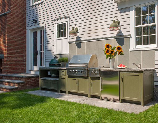 Outdoor kitchen with built-in cabinets, outdoor lighting and stone backsplash. Siemasko + Verbridge