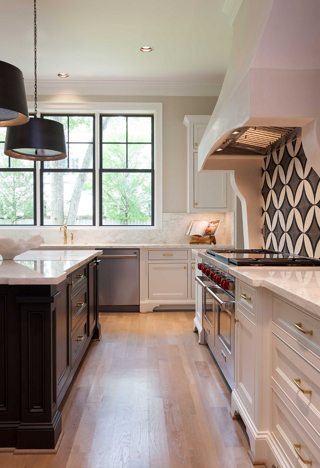 White kitchen with dark island and white oak hardwood floors. Elizabeth Garrett Interiors