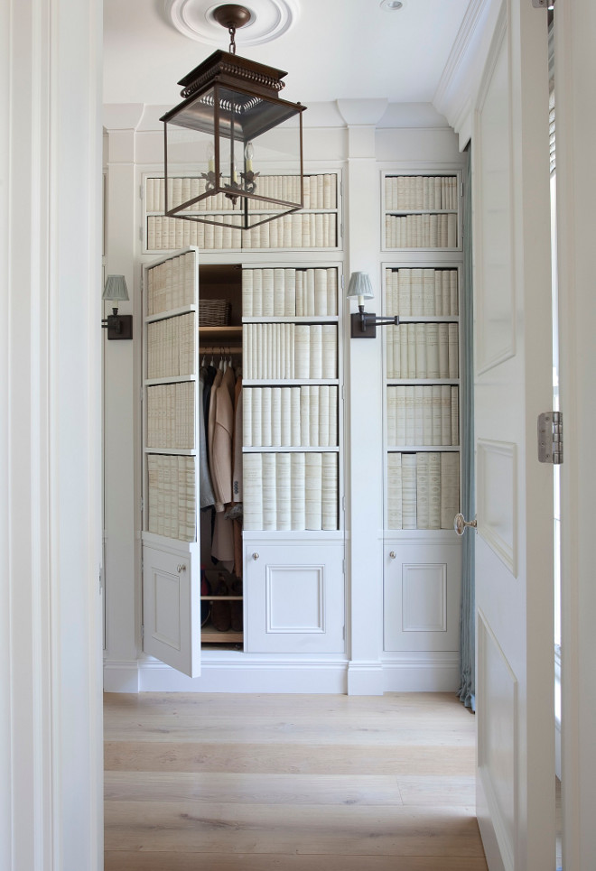 Entry built-in closet. The foyer features cabinet doors with faux ceramic books and sconces. The cabinet conceals a hidden closet. #foyer #entry #entryway #closet Lighting is Circa Lighting's Honore Hanging Lantern. Hayburn & Co. 