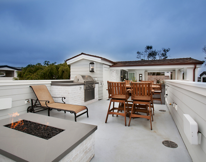 This roof deck is the perfect place to unwind on a summer night! The fire pit and built in barbeque are both made up of the same white brick used on the home's exterior and topped with neolith lava stone slabs. Roof Deck Ideas. Patterson Custom Homes