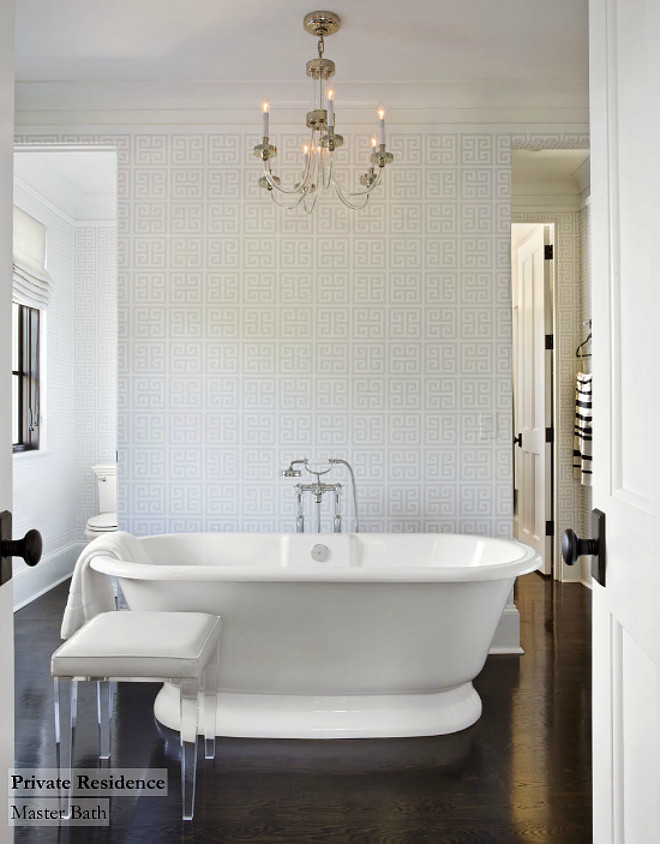 Bathroom. Fabulous bathroom with Jonathan Adler Greek Key Wallpaper in White. This bathroom also features a glass and polished nickel chandelier over freestanding bathtub with floor-mounted tub filler paired with upholstered lucite stool. Notice the dark stained oak wood floors. #bathroom #woodfloors #hardwood #bathrooms #flooring TS Adams Studio Architects. Traci Rhoads Interiors.