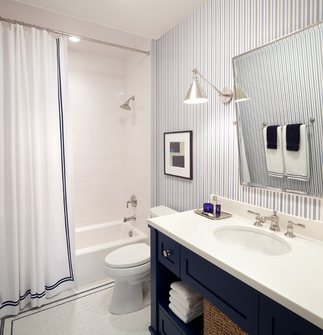 Blue and white bathroom with striped wallpaper. Blue and white bathroom with striped wallpaper and navy vanity with white countertop. #bathroom #blueandwhite #striped #wallpaper #navyvanity #blue #white #navycabinet #whitecountertop Kurt Baum & Associates.