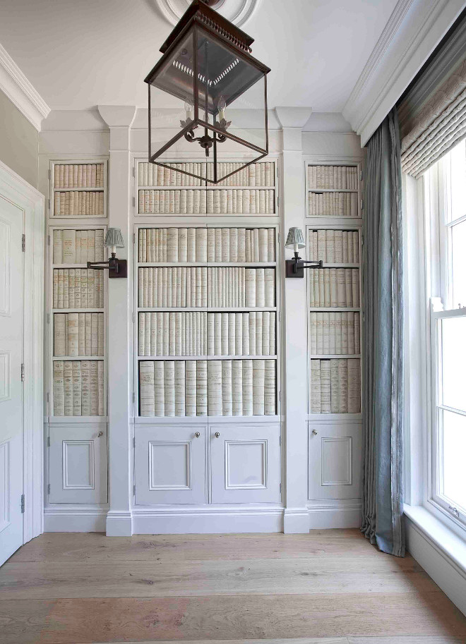 Foyer closet. Foyer closet ideas. This foyer is truly inspiring! The space features cabinet doors with faux ceramic books and sconces. The cabinet conceals a hidden closet. Lighting is Circa Lighting's Honore Hanging Lantern #foyer #closet #foyercloset #design #interiors Hayburn & Co. 