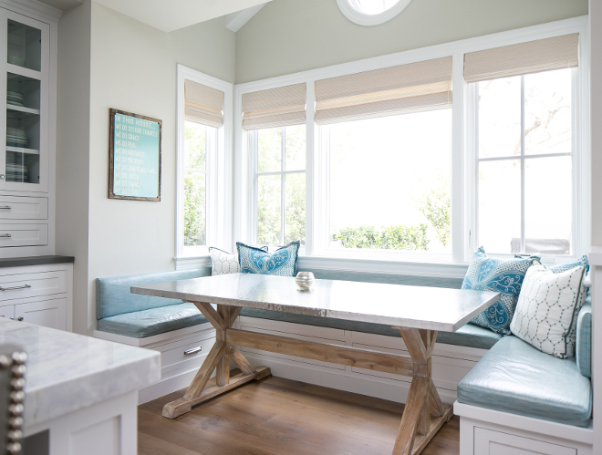 Breakfast nook. This breakfast nook is perfect for this family with small children. The table features stainless steel top on reclaimed wood trestle table base and the laminated fabric on the banquette is a mom's dream! #Breakfastnook #banquette #laminatefabric #table Churchill Design. 