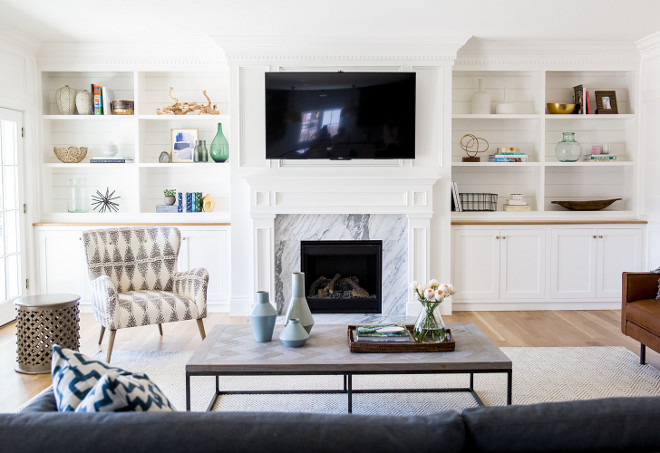 Living room cabinet. The living room is light and fresh with this fireplace with white marble and white cabinets with shiplap on shelves. #Livingroom #Fireplace #cabinet #shiplap Studio McGee.