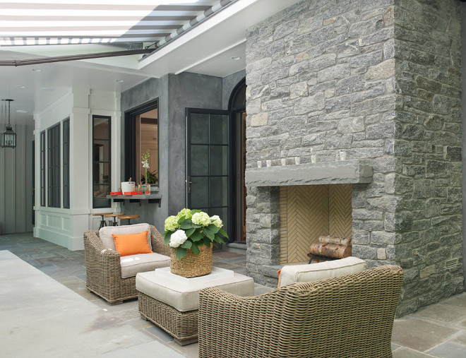 Outdoor Stone Fireplace and stone patio. Stone fireplace is Byram black fieldstone. The stone patio floor tiles is bluestone