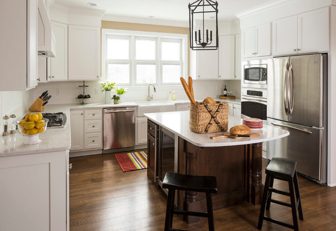 Traditional white kitchen with dark stained kitchen island. Cabinets are painted in White Dove by Benjamin Moore and Walls are painted in Benjamin Moore Shaker Beige. Traditional kitchen. #Kitchen #TradtionalKitchen #StainedIsland Renae Keller Interior Design, Inc.