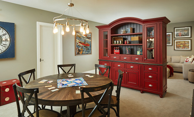 Basement Ideas. Smart Basement Ideas. Basement Design Ideas. Red Cabinet in basement is custom by Benchmark Wood Studio and is a two sided piece with TV on one side and shelving on the other. Serves as a buffer to the game space and lounging area. #BasementIdeas #Basementdesignideas #Basements